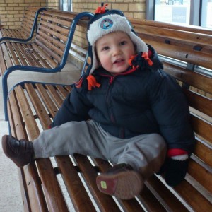 Waiting for a train in Thomas hat and mittens