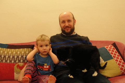 The Little Monkey hides from the camera flash behind a conveniently positioned feline.